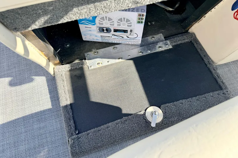 Slide: The Image of Bennington 205L 2005 boat interior with audio system and carpeted flooring. - 45