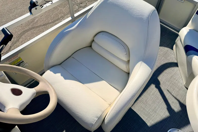 Slide: The Image of Captain's seat of a 2005 Bennington 205L pontoon boat, featuring white upholstery. - 46