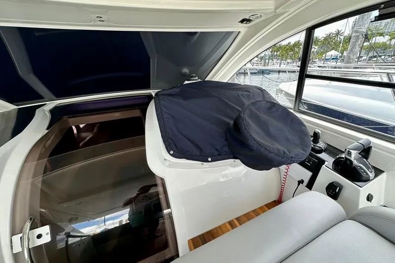 Slide: The Image of 2012 Beneteau Gran Turismo 34 cockpit with covered helm, modern controls, and marina view. - 14