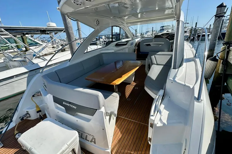 Slide: The Image of 2012 Beneteau Gran Turismo 34 yacht interior with seating and wooden table at marina. - 26