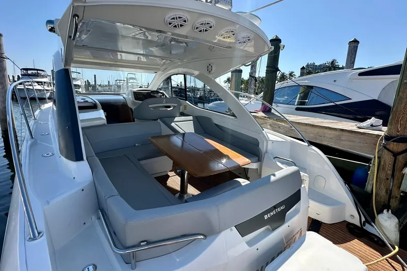 Slide: The Image of 2012 Beneteau Gran Turismo 34 yacht with sleek seating and wooden table in marina. - 27