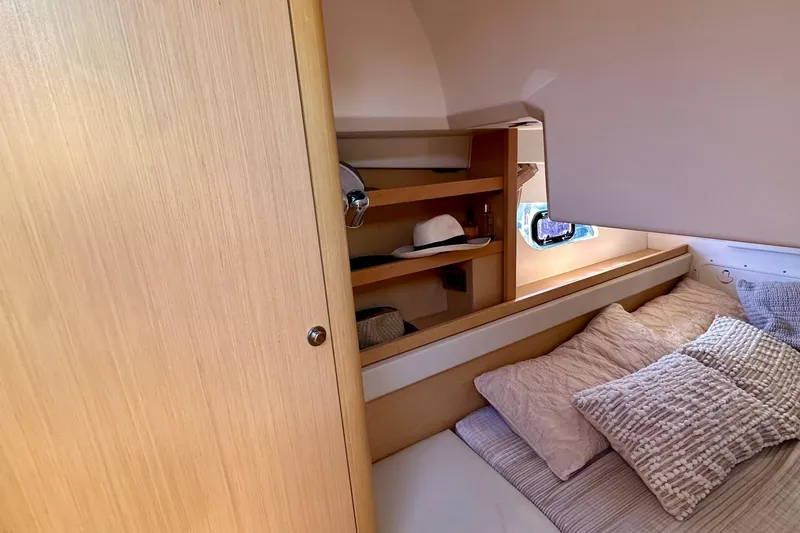Slide: The Image of Cozy cabin interior of 2012 Beneteau Gran Turismo 34 with wooden shelves and plush bedding. - 35