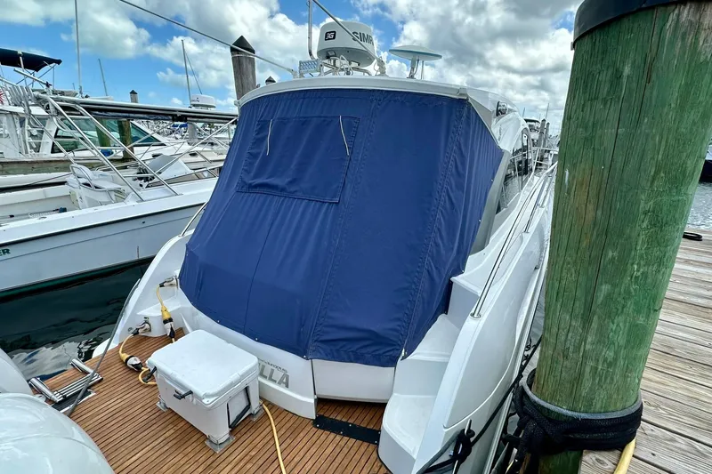 Slide: The Image of 2012 Beneteau Gran Turismo 34 yacht docked, featuring blue cover and wooden deck. - 8