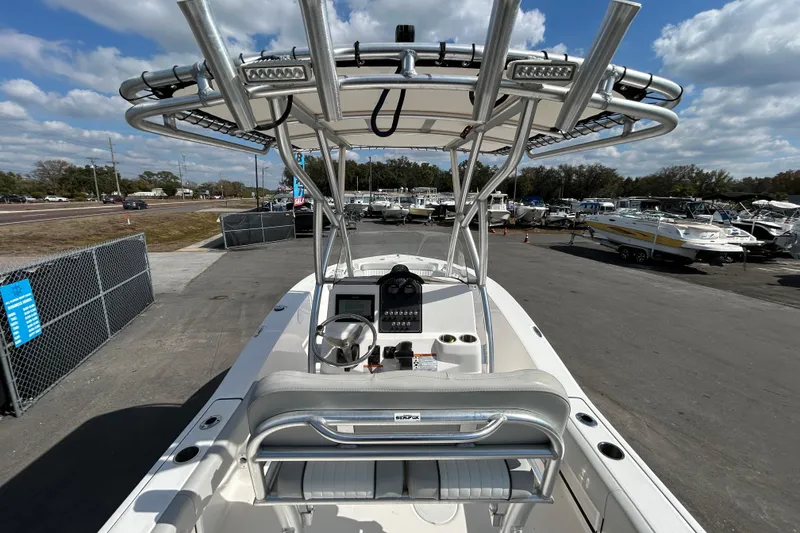 Slide: The Image of 2022 Sea Fox 206 Commander boat with T-top, parked in a marina under a cloudy sky. - 17