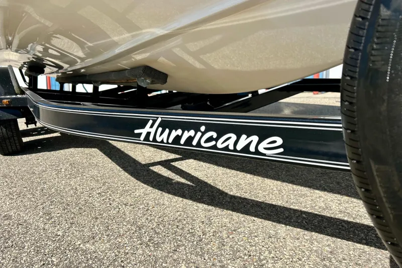 Slide: The Image of 2019 Hurricane SunDeck Sport 201 OB boat trailer close-up on pavement. - 13