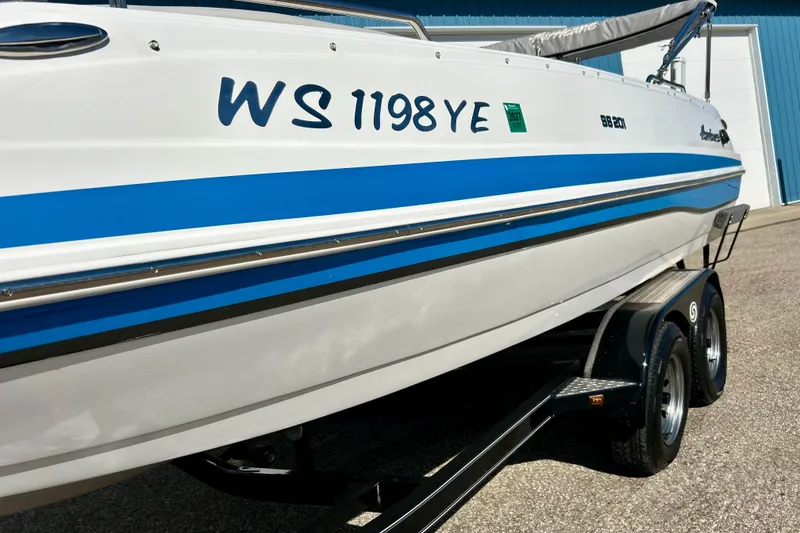 Slide: The Image of 2019 Hurricane SunDeck Sport 201 OB boat on trailer, blue stripe, registration visible. - 14
