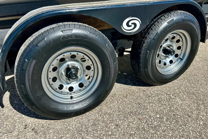 Slide: The Image of Trailer wheels for 2019 Hurricane SunDeck Sport 201 OB on asphalt surface. - 17
