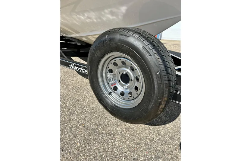 Slide: The Image of 2019 Hurricane SunDeck Sport 201 OB trailer tire on asphalt. - 18