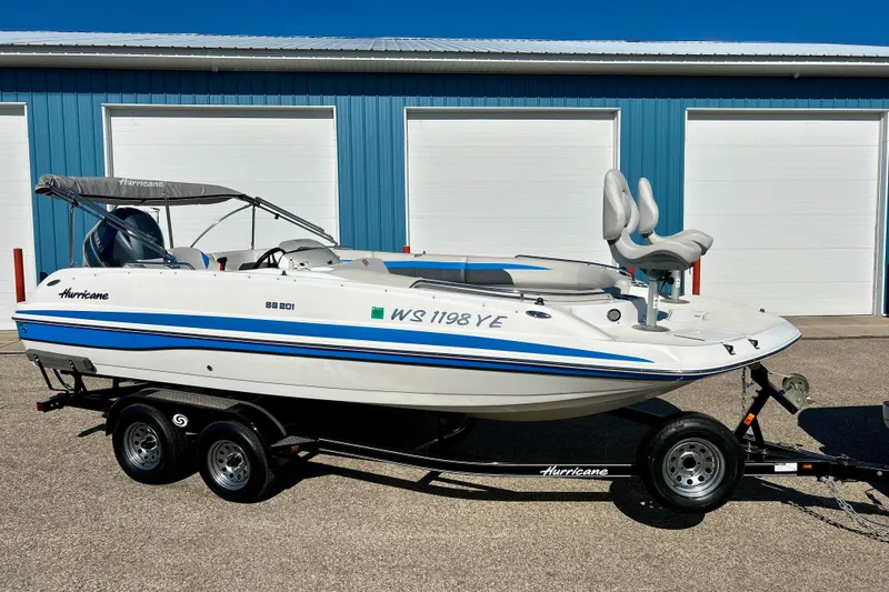 Slide: The Image of 2019 Hurricane SunDeck Sport 201 OB boat on trailer, parked by blue garage doors. - 66