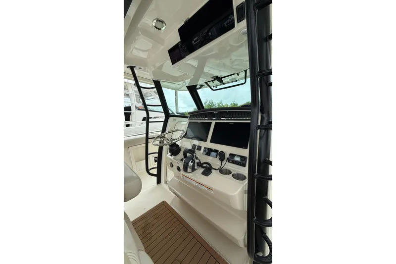 Slide: The Image of 2022 Boston Whaler 380 Outrage helm with modern controls and sleek design. - 11