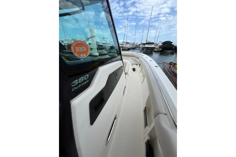 Slide: The Image of 2022 Boston Whaler 380 Outrage docked at marina, showcasing sleek design and spacious deck. - 3