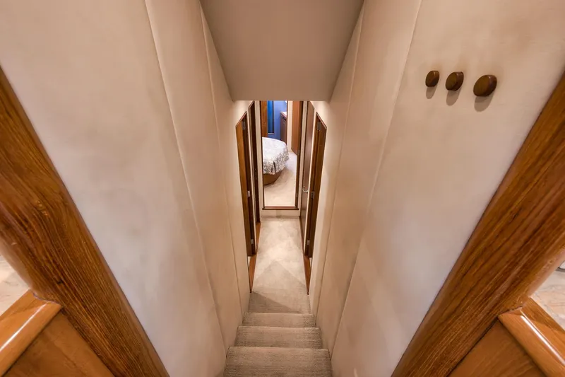 Slide: The Image of Interior hallway of 1997 Merritt 58 yacht with wooden accents and carpeted stairs. - 133