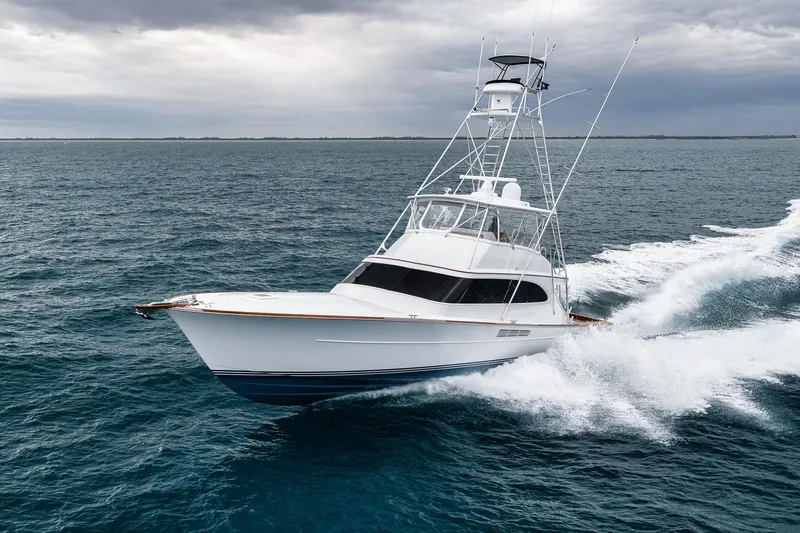 Slide: The Image of A 1997 Merritt 58 yacht cruising on open water under cloudy skies. - 2