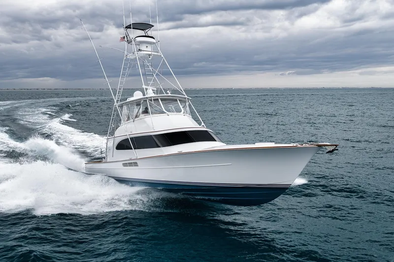 Slide: The Image of Sportfishing yacht Merritt 58, 1997 model, cruising on open ocean under cloudy skies. - 23