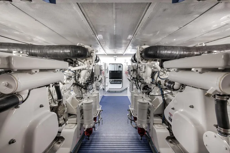 Slide: The Image of Engine room of a 1997 Merritt 58 yacht, featuring dual engines and blue flooring. - 53