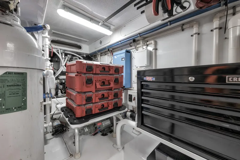Slide: The Image of Engine room of a 1997 Merritt 58 boat with toolboxes and equipment. - 62