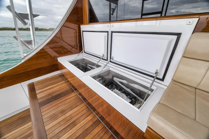 Slide: The Image of Luxury Merritt 58 yacht interior with open storage compartments, wooden flooring, and beige seating. - 71