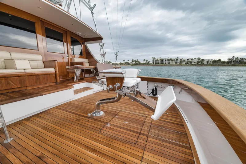 Slide: The Image of Luxurious 1997 Merritt 58 yacht deck with wooden flooring and seating, overlooking calm waters. - 87