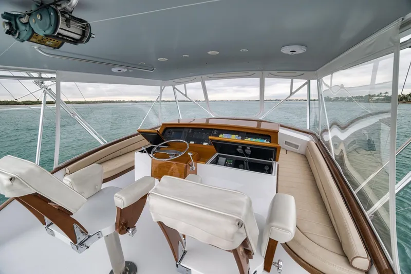 Slide: The Image of Cockpit of 1997 Merritt 58 yacht with steering wheel and seating, overlooking the ocean. - 100