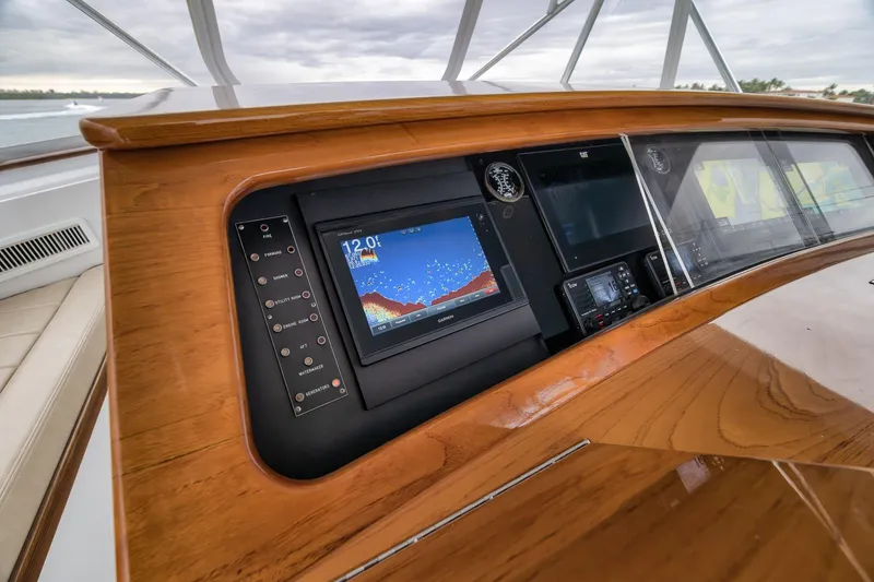Slide: The Image of Control panel of a 1997 Merritt 58 yacht with navigation screens and wooden finish. - 112