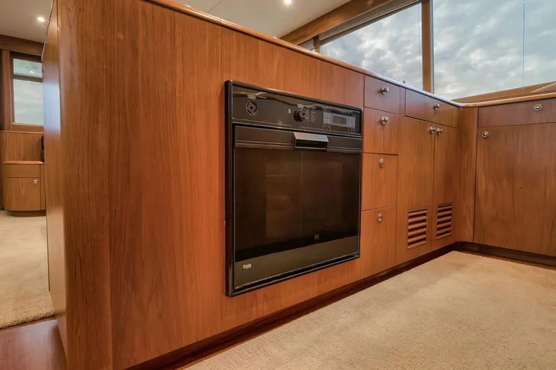 Slide: The Image of Wood-paneled kitchen interior of 1997 Merritt 58 yacht with built-in oven. - 131
