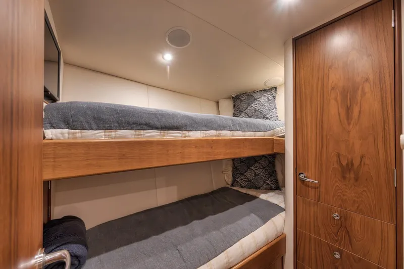 Slide: The Image of Cozy bunk beds in a 1997 Merritt 58 yacht cabin with wooden accents. - 147