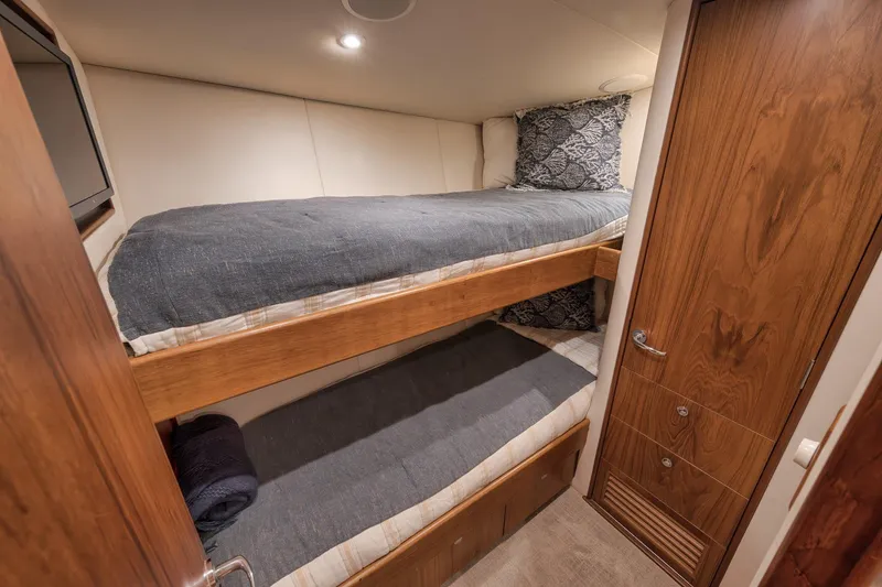 Slide: The Image of Cozy bunk beds in a 1997 Merritt 58 yacht cabin with wooden accents. - 148