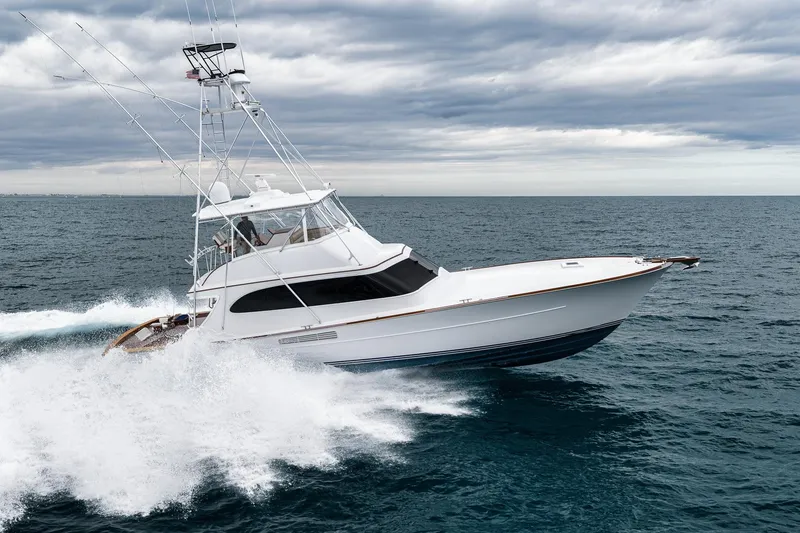Slide: The Image of Sportfishing yacht Merritt 58, 1997 model, cruising on open ocean under cloudy skies. - 26