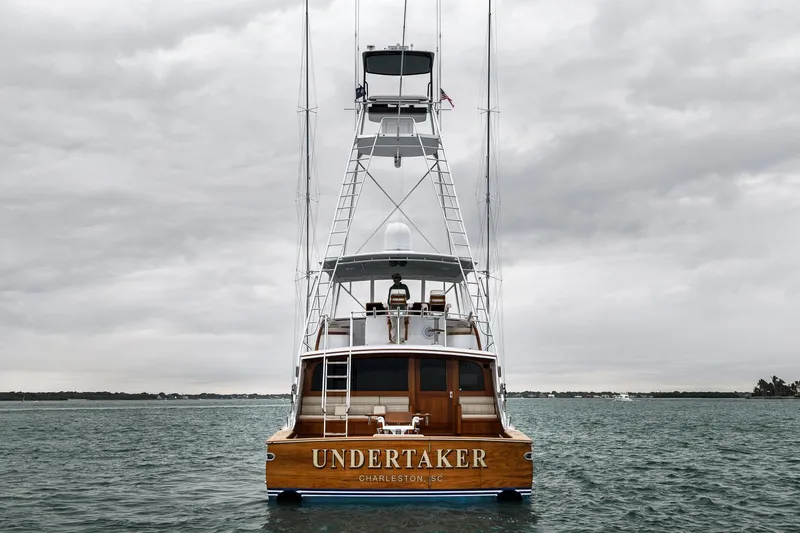 Slide: The Image of Sleek 1997 Merritt 58 yacht "Undertaker" on calm waters under cloudy skies. - 35