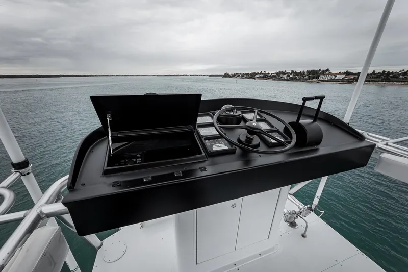 Slide: The Image of Helm of 1997 Merritt 58 yacht overlooking calm waters and distant shoreline. - 49