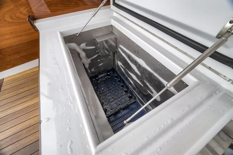 Slide: The Image of Open storage compartment on 1997 Merritt 58 boat with wooden deck and metal hinges. - 72