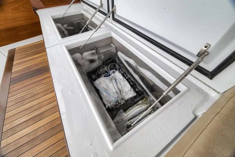 Slide: The Image of Open storage compartments on a 1997 Merritt 58 boat, featuring wooden deck and metal hinges. - 73