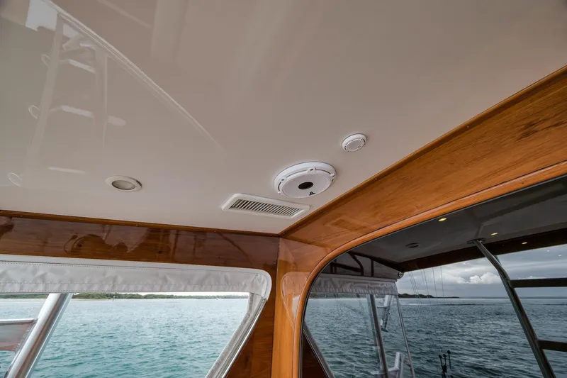 Slide: The Image of Interior view of a 1997 Merritt 58 yacht, featuring wood paneling and ceiling fixtures. - 96