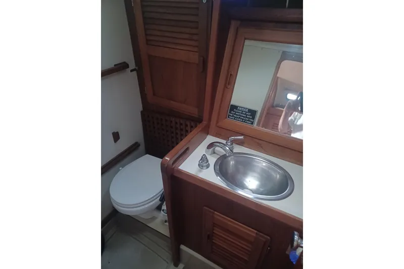 Slide: The Image of 1987 O'Day 40 yacht bathroom with wooden cabinetry, sink, and toilet. - 17