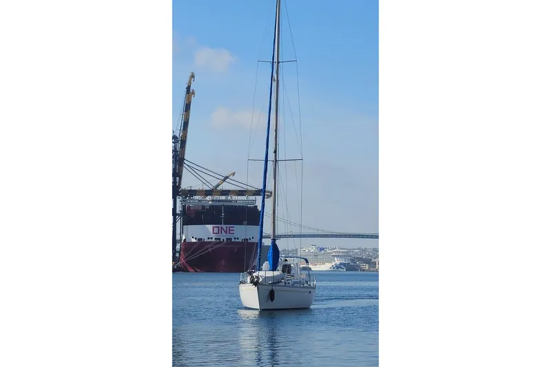 Slide: The Image of 1987 O'Day 40 sailboat in harbor with cargo ship and cranes in background. - 4