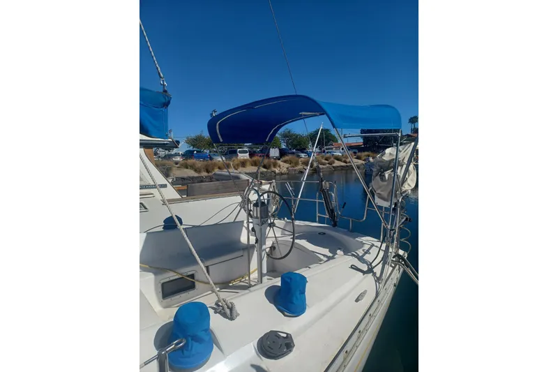 Slide: The Image of 1987 O'Day 40 sailboat with blue canopy docked in a marina. - 7