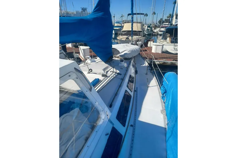 Slide: The Image of 1987 O'Day 40 sailboat docked, featuring blue covers and a sleek white deck. - 9