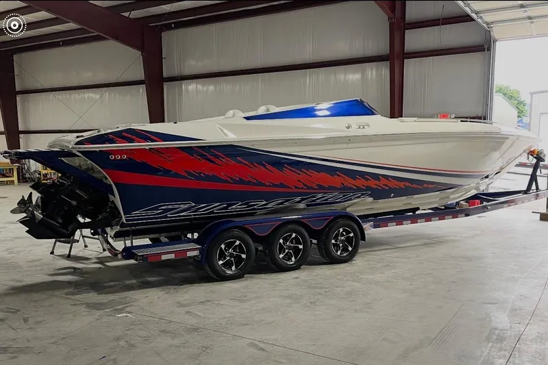 Slide: The Image of 2008 Sunsation 32 Mid-Cabin boat with vibrant graphics on a trailer in a warehouse. - 16
