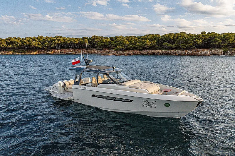 Slide: The Image of 2024 Wiszniewski Yachts W43 cruising on serene waters near a forested coastline. - 4