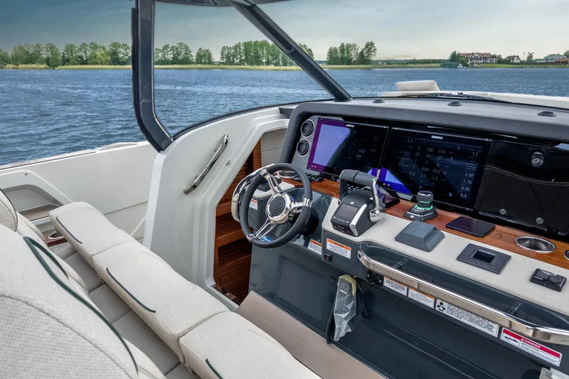 Slide: The Image of Luxurious 2026 Wiszniewski Yachts W43 cockpit with advanced navigation systems on a serene lake. - 5