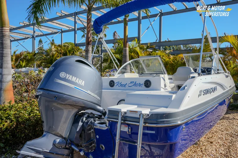 Slide: The Image of 2018 Starcraft MDX 190 O/B boat with Yamaha engine, parked outdoors near palm trees. - 10