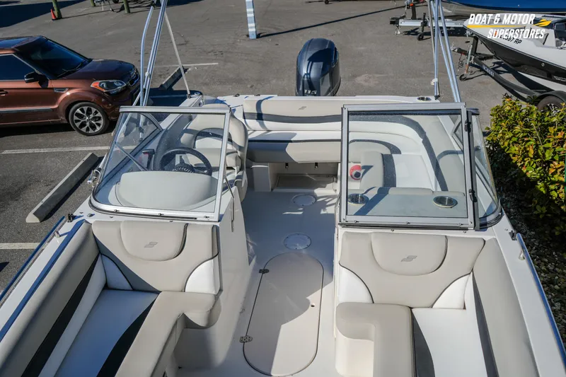 Slide: The Image of 2018 Starcraft MDX 190 O/B boat interior with seating and steering wheel, parked outdoors. - 29