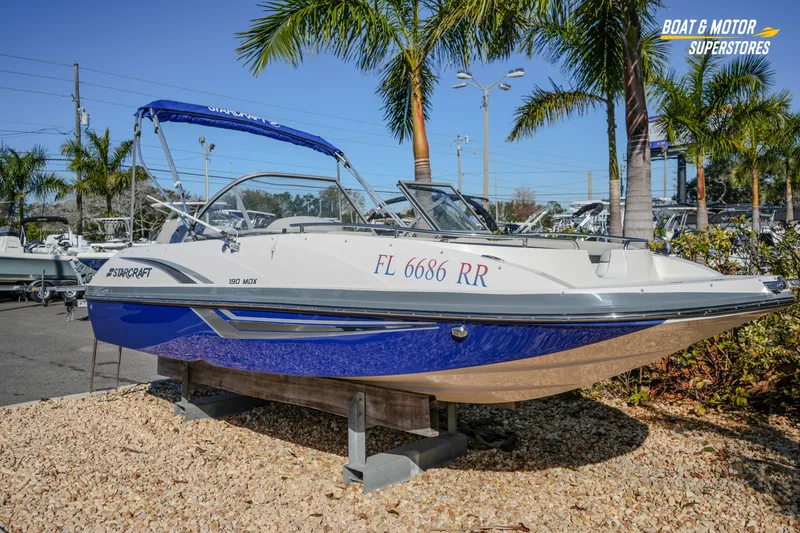 Slide: The Image of 2018 Starcraft MDX 190 O/B boat displayed outdoors with palm trees. - 3