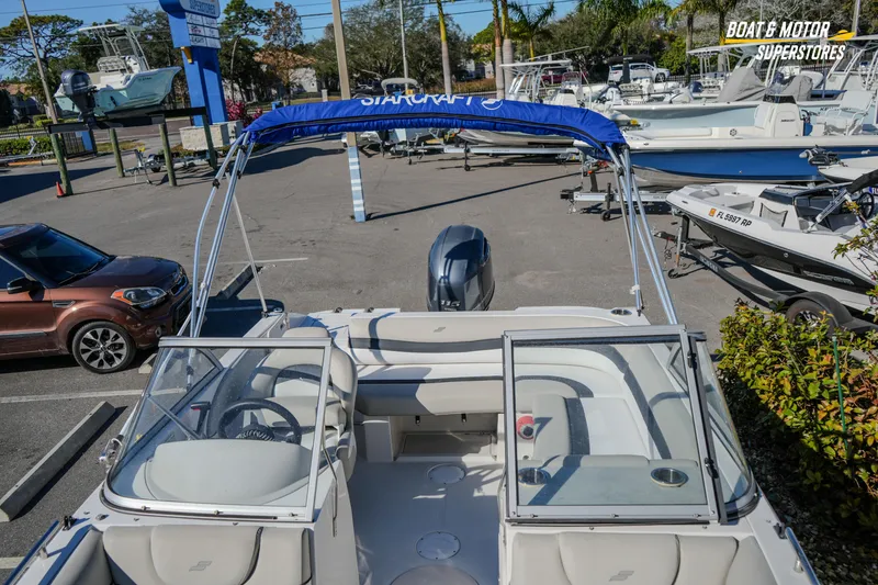Slide: The Image of 2018 Starcraft MDX 190 O/B boat with blue canopy in a dealership lot. - 30
