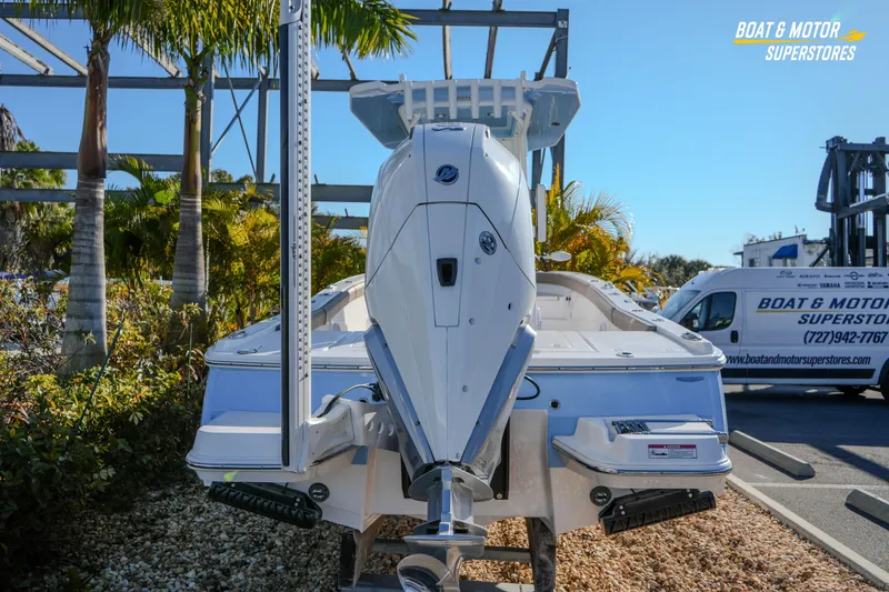 Slide: The Image of 2025 Blackfin 242 HB boat displayed at dealership with palm trees and van in background. - 14