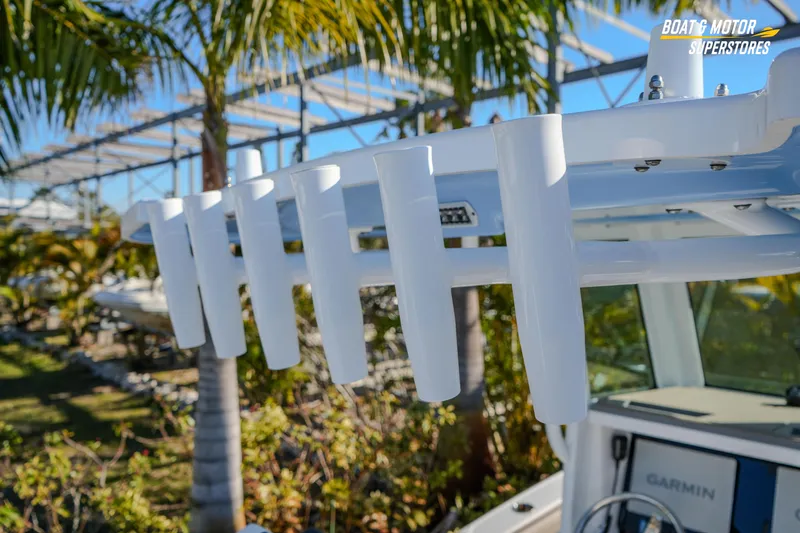 Slide: The Image of 2025 Blackfin 242 HB boat with rod holders, palm trees in background. - 24