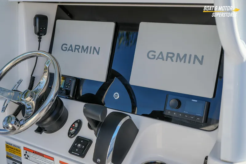 Slide: The Image of 2025 Blackfin 242 HB boat dashboard with Garmin navigation displays and steering wheel. - 27
