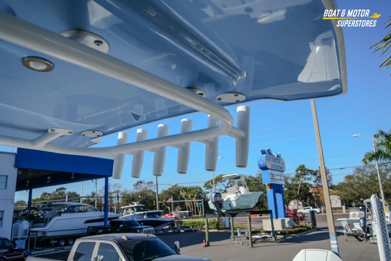 Slide: The Image of 2025 Blackfin 242 HB boat detail at dealership, showcasing rod holders and sleek design. - 47