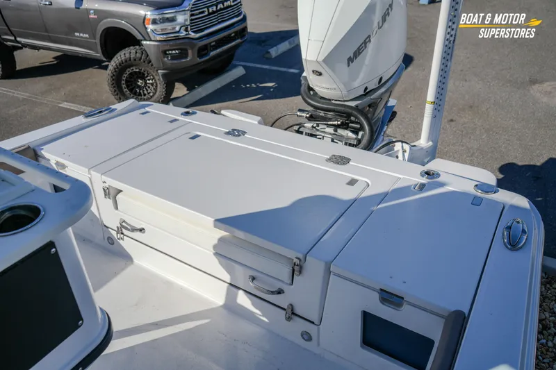 Slide: The Image of 2025 Blackfin 242 HB boat with Mercury engine, parked near a RAM truck. - 48