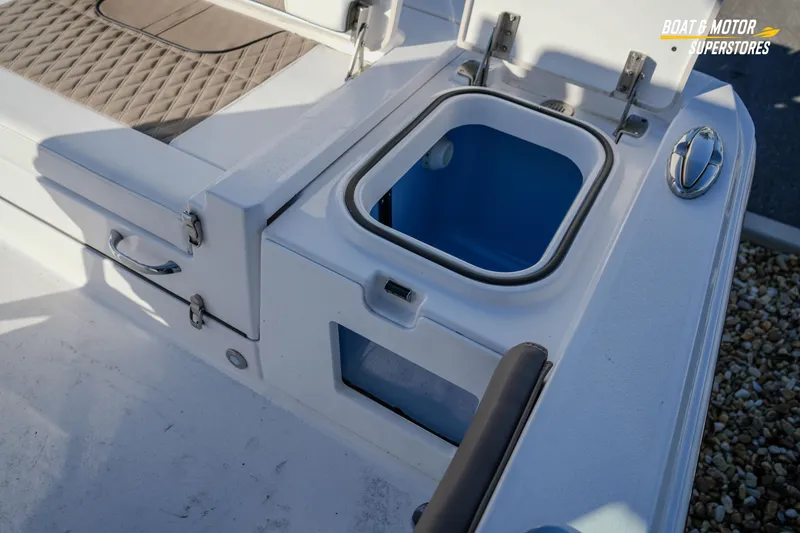 Slide: The Image of 2025 Blackfin 242 HB boat with open storage compartment and cushioned seating. - 50